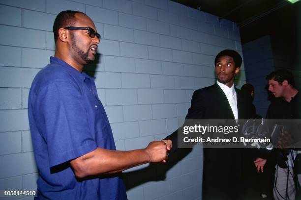 Kobe Bryant of the Los Angeles Lakers shakes hands with his dad Joe Bryant during Game Four of the First Round of the 1998 NBA Playoffs on April...