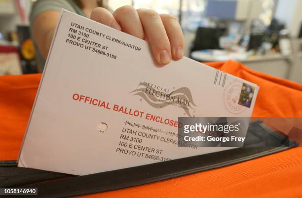 November 6: A employee at the Utah County Election office puts mail in ballots into a container to register the vote in the midterm elections on...