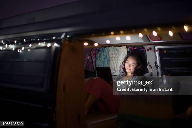 young woman sitting in her camper van at night - wonderlust computer stock pictures, royalty-free photos & images