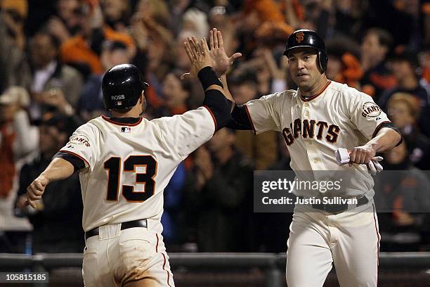 Cody Ross and Pat Burrell of the San Francisco Giants celebrate after scoring on a double by Pablo Sandoval in the sixth inning of Game Four of the...