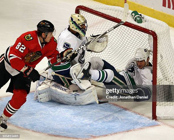 Kevin Bieksa of the Vancouver Canucks falls over Roberto Luongo on an interference call against Tomas Kopecky of the Chicago Blackhawks at the United...