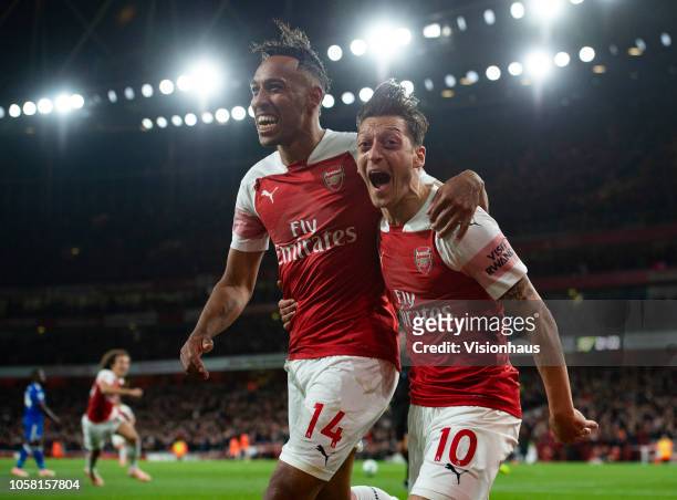 Pierre-Emerick Aubamayang of Arsenal celebrates with Mesut Ozil after scoring Arsenal's third goal during the Premier League match between Arsenal FC...