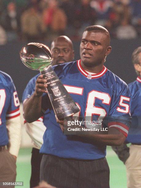 East Rutherford, N.J.: Former New York Giants linebacker Lawrence Taylor holds the Vince Lombardi Trophy at a ceremony honoring the 1986 Super Bowl...