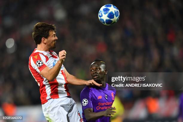 Red Star Belgrade's Montenegrin defender Filip Stojkovic vies for the ball with Liverpool's Senegalese midfielder Sadio Mane during the UEFA...