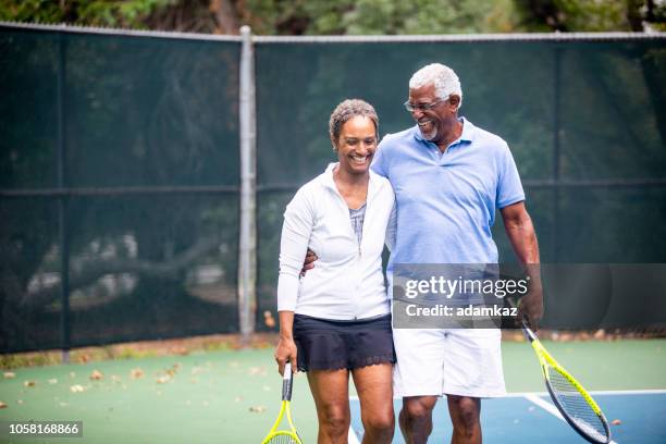 senior black couple on tennis court - tennis adult stock pictures, royalty-free photos & images