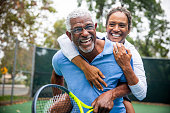 Senior Black Couple on Tennis Court Piggyback