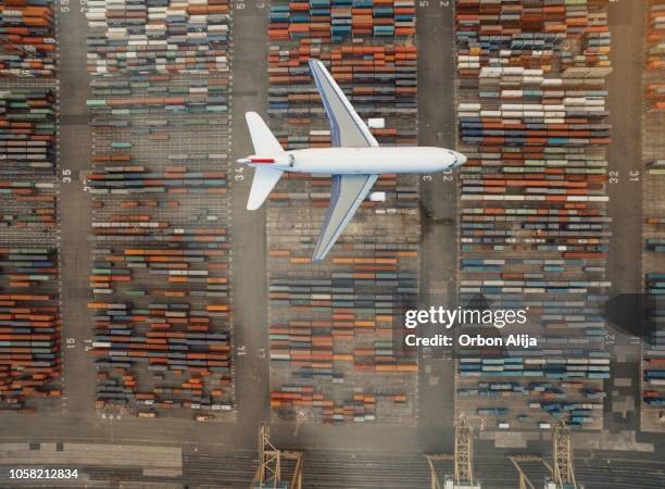 airplane flying over container port - veículo aéreo imagens e fotografias de stock