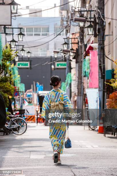 woman wearing kimono walking in a street, tokyo, japan - kimono stockfoto's en -beelden