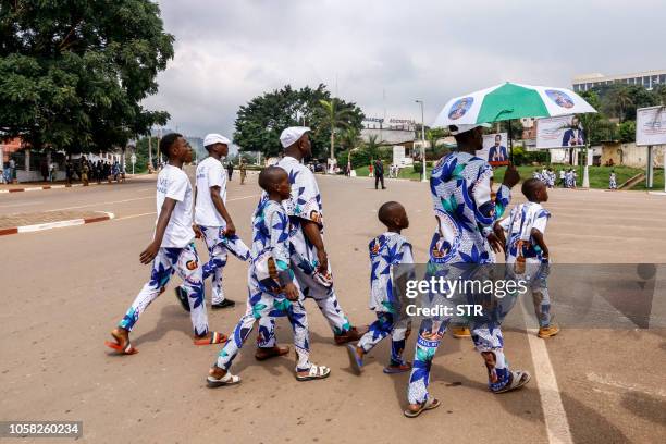 Supporters of Cameroonian President Paul Biya wear clothing emblazoned with his image as they celebrate his re-election in Yaoundé on November 6,...