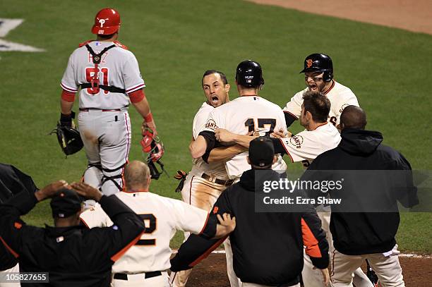 Andres Torres of the San Francisco Giants hugs Aubrey Huff after Huff scored on a sacrifice fly by Juan Uribe to beat the Philadelphia Phillies 6-5...