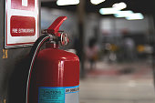 closeup red fire extinguisher with soft-focus and over light in the background