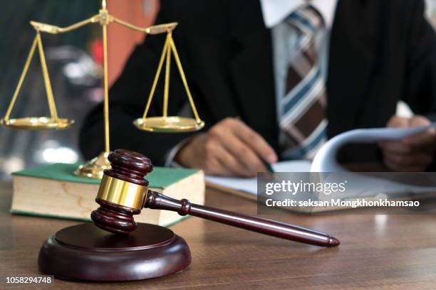 judge gavel with justice lawyers having team meeting at law firm in background. concepts of law. - studio legale foto e immagini stock