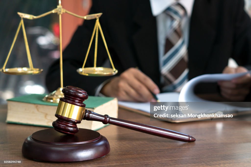 Judge gavel with Justice lawyers having team meeting at law firm in background. Concepts of law.