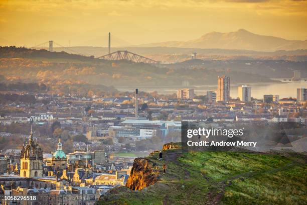 edinburgh cityscape and skyline with firth of forth at sunset from holyrood park - kleinstadt ansicht stock-fotos und bilder