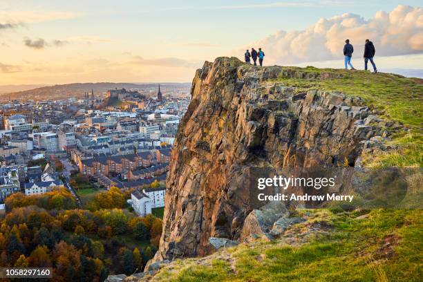 salisbury crags, holyrood park with edinburgh city the in background at sunset - arthur's seat - fotografias e filmes do acervo