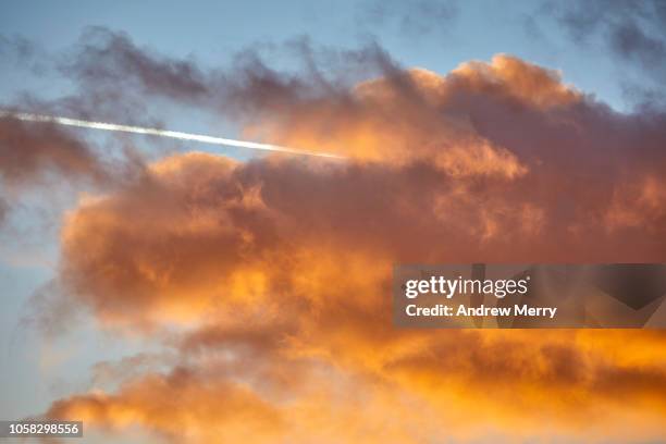 clouds at sunset with vapour trail - sunset with jet contrails stock pictures, royalty-free photos & images