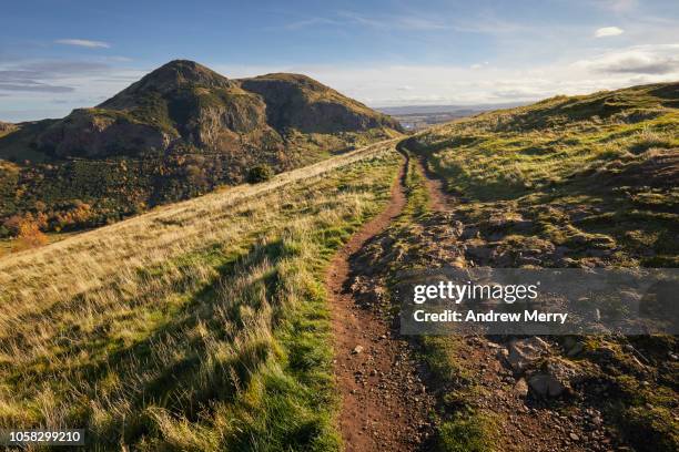 arthur's seat peak, summit, walking path on salisbury crags holyrood park, edinburgh - colina fotografías e imágenes de stock