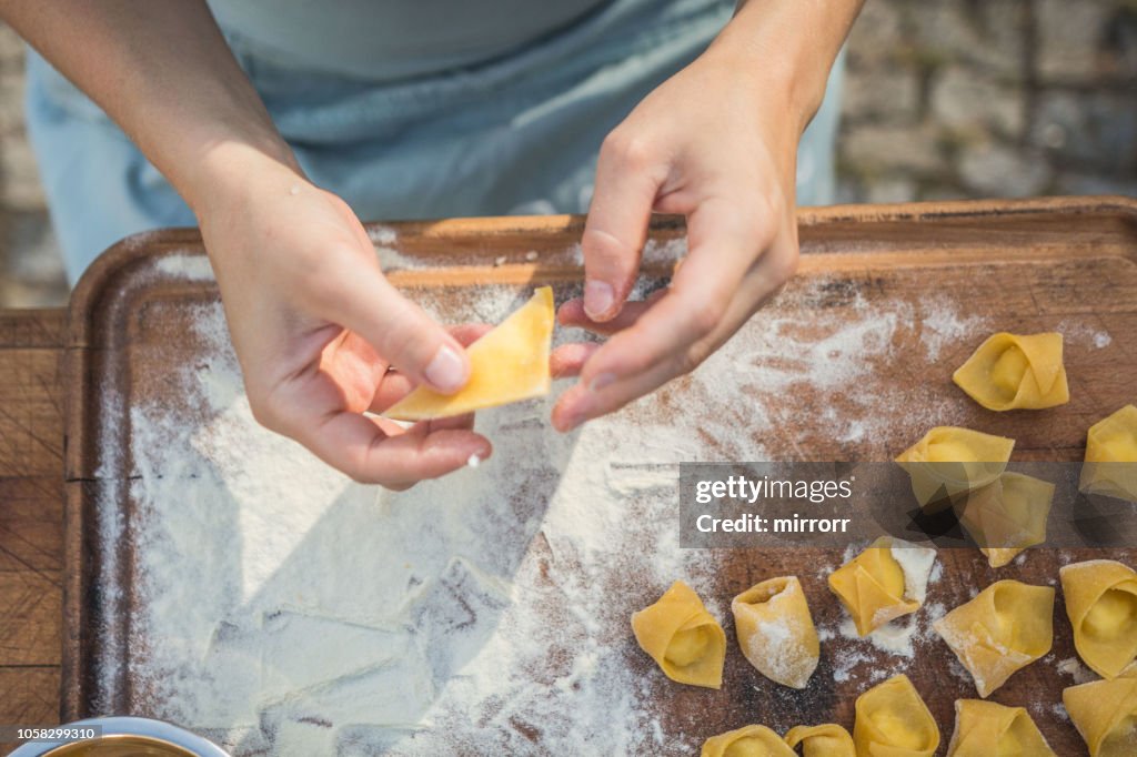 Chef prepara tortellini di pasta ripieni fatti a mano