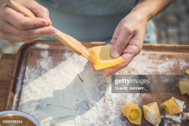 koch bereitet handgemachte gefüllte pasta tortellini - ombelico stock-fotos und bilder