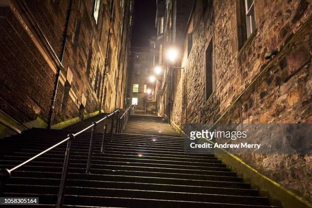 warriston's close steep staircase at night with bright street lights, old town, edinburgh - sandstone wall stockfoto's en -beelden