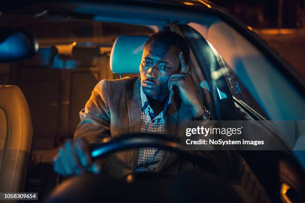 handsome businessman on a business trip, driving at night. african ethnicity - tired driver stock pictures, royalty-free photos & images