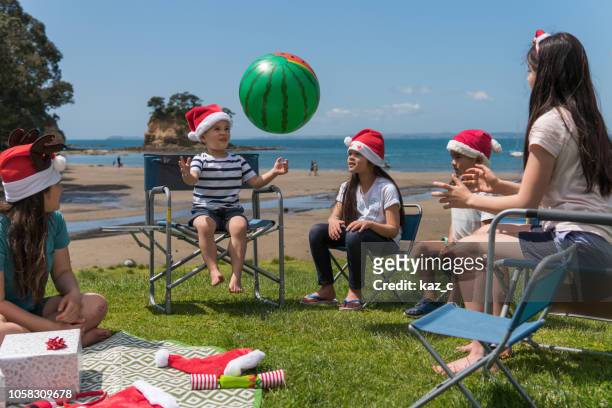 children having fun at a christmas beach party - summer christmas stock pictures, royalty-free photos & images