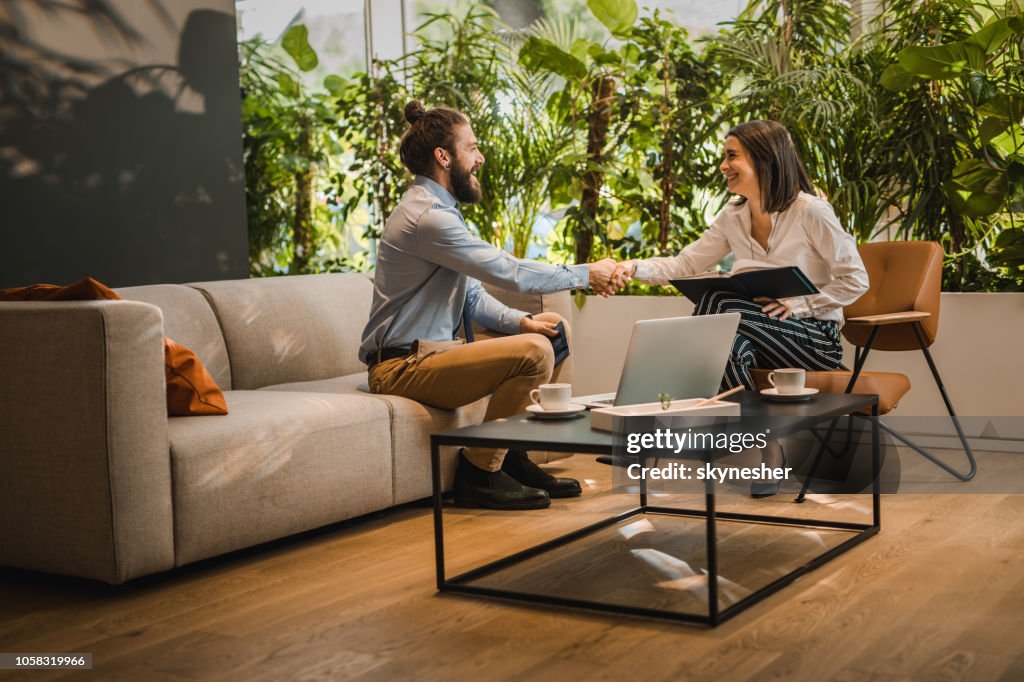 Young happy business colleagues shaking hands in the office.