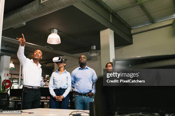 young african man explaining new office layout to client with vr headset - augmented reality office stock pictures, royalty-free photos & images