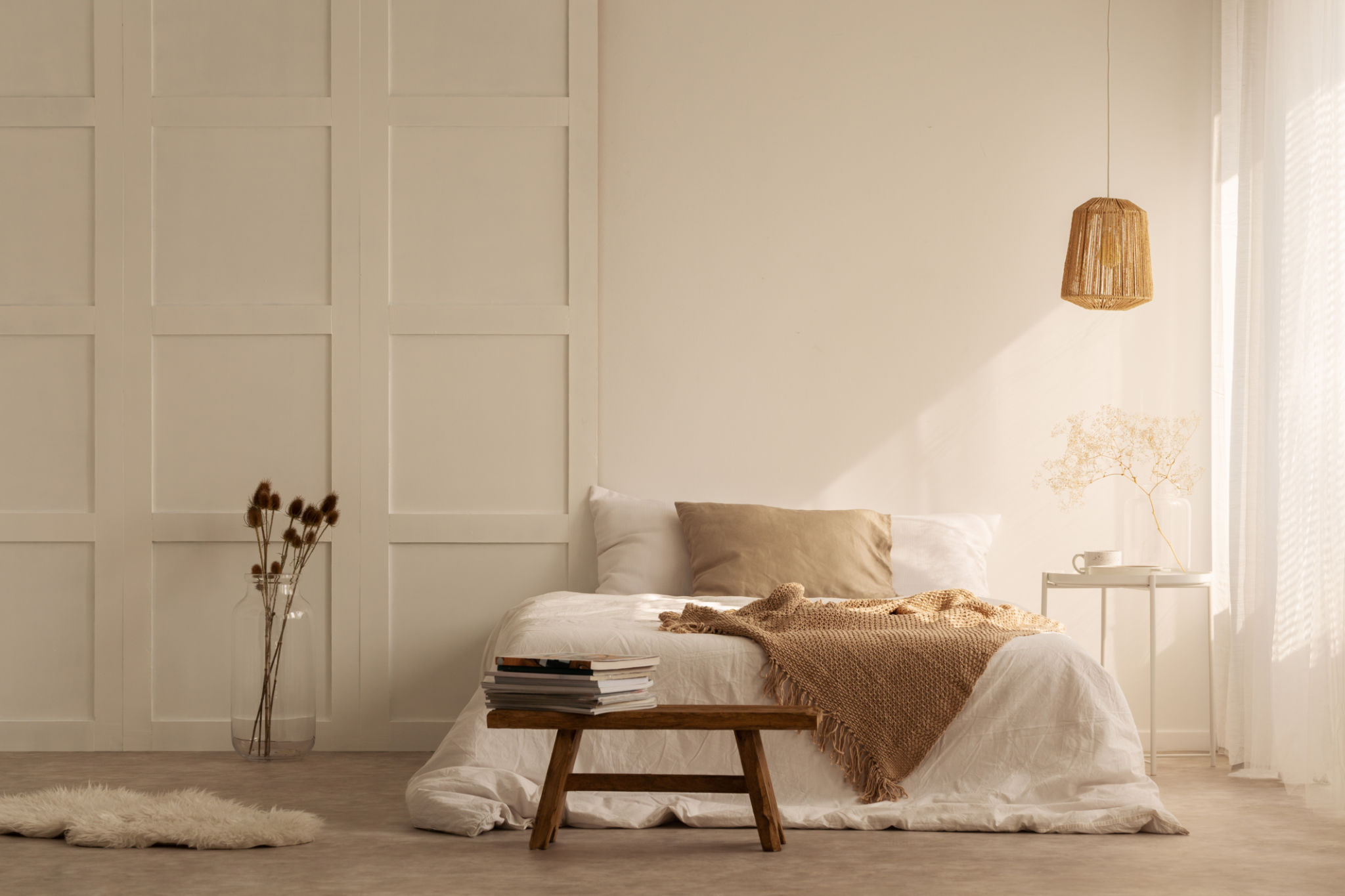 Beige blanket on the double bed in stylish wabi sabi bedroom of minimal style house, real photo with copy space on the empty wall Beige blanket on the double bed in stylish wabi sabi bedroom of minimal style house, real photo with copy space on the empty wall