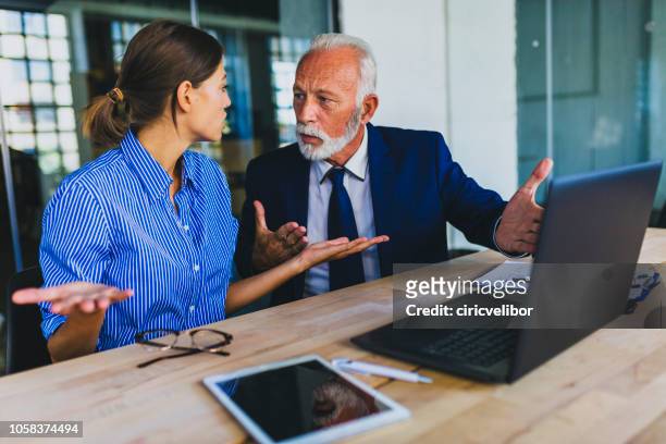 colleagues arguing at workplace - employee conflict stock pictures, royalty-free photos & images