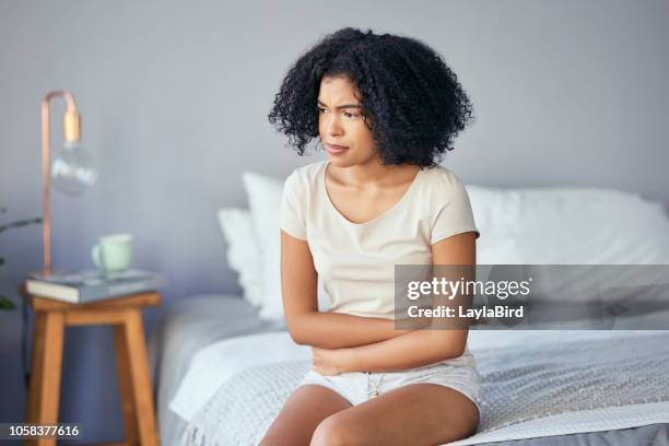 she's a little under the weather - women touching herself in bed stock pictures, royalty-free photos & images