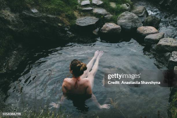 woman resting in wild hot spring in iceland - hot spring stock pictures, royalty-free photos & images