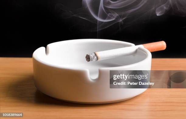 lit cigarette, burning in ashtray - tobacco product imagens e fotografias de stock