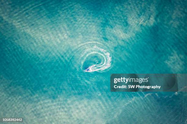 a sailing boat is driving a cycle in the middle of the ocean - province de chonburi photos et images de collection