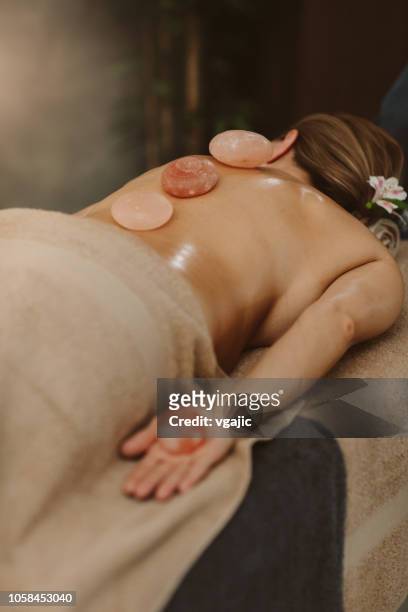 masaje de espalda - terapia lastone fotografías e imágenes de stock