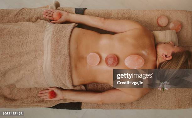 masaje de espalda - terapia lastone fotografías e imágenes de stock