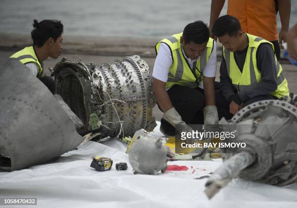 Investigators examine engine parts from the ill-fated Lion Air flight JT 610 at a port in Jakarta on November 7 after they were recovered from the...