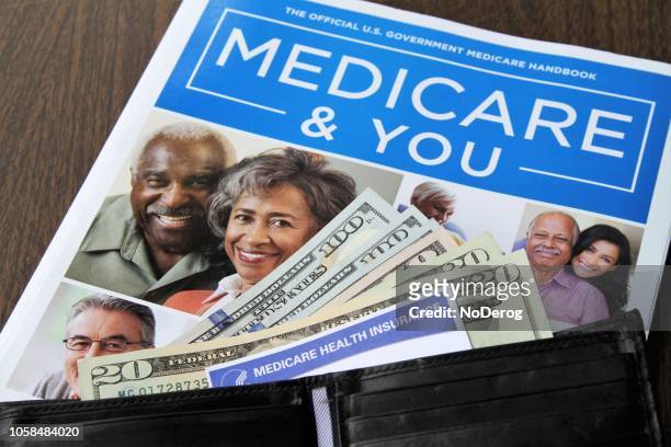 medicare and social security cards with cash and medicare handbook - medicare supplement stock pictures, royalty-free photos & images