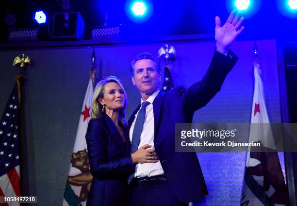 Democratic gubernatorial candidate Gavin Newsom joined by his wife Jennifer Siebel Newsom waves to supporters during election night event on November...