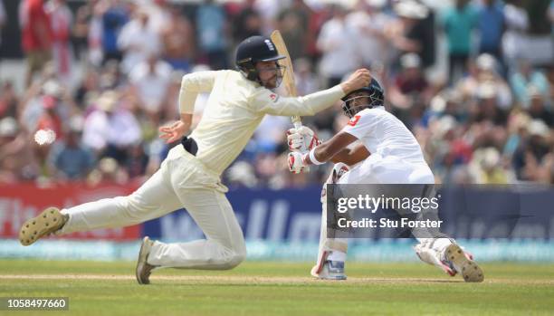 England fielder Rory Burns dives as Sri Lanka batsman Dinesh Chandimal sweeps for some runs during Day Two of the First Test match between Sri Lanka...