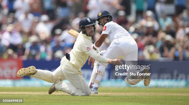 England fielder Rory Burns dives as Sri Lanka batsman Dinesh Chandimal sweeps for some runs during Day Two of the First Test match between Sri Lanka...