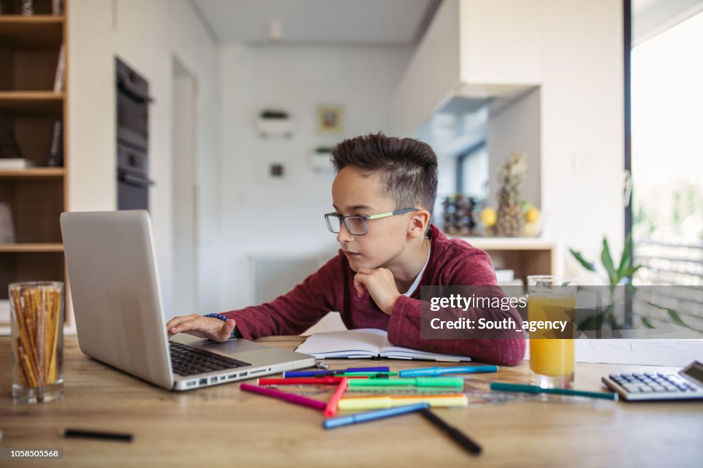 Boy doing homework on laptop