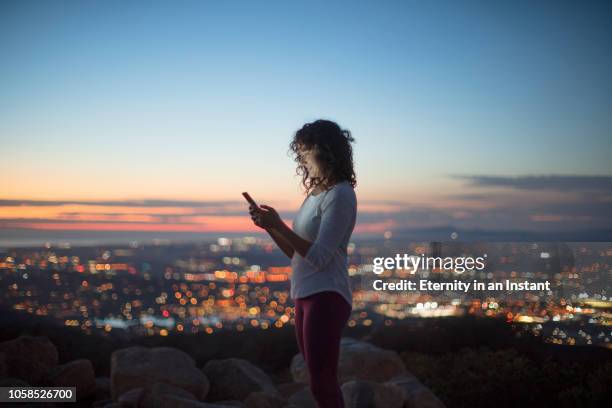 young woman texting on her phone at night - california mountains stock pictures, royalty-free photos & images