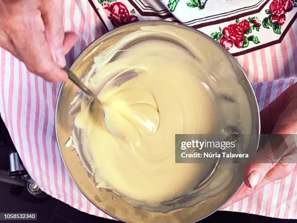 hands of a disabled old woman mixing melted white chocolate in a bowl - chocolat blanc photos et images de collection