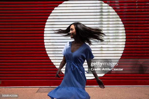 portrait of happy woman spinning on street - perth street stock pictures, royalty-free photos & images