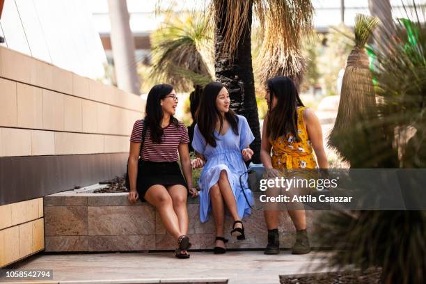 three young women sitting and chatting in city - perth street stock pictures, royalty-free photos & images