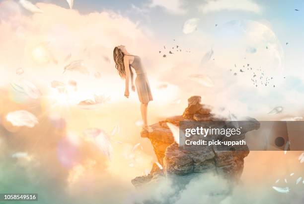 woman falling backwards off cliff into heaven - falling feathers stock pictures, royalty-free photos & images