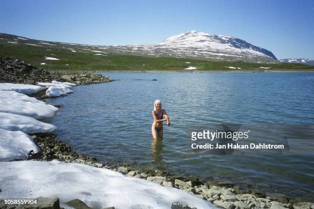 woman bathe in lake in snowy mountains - eis baden stock-fotos und bilder
