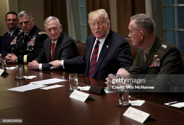 President Donald Trump reaches out to touch the arms of Chairman of the Joint Chiefs of Staff Joseph Dunford and U.S. Defense Secretary Jim Mattis...