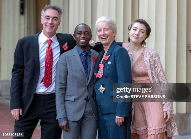 English actor Emma Thompson poses with her husband Greg Wise , and children Gaia Wise and Tindy Agaba, whilst wearing her medal and insignia after...